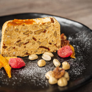 Ambachtelijke Banoffee nougat van ZinZetion met banaan en karamel, vers gesneden op een zwart stenen bord.