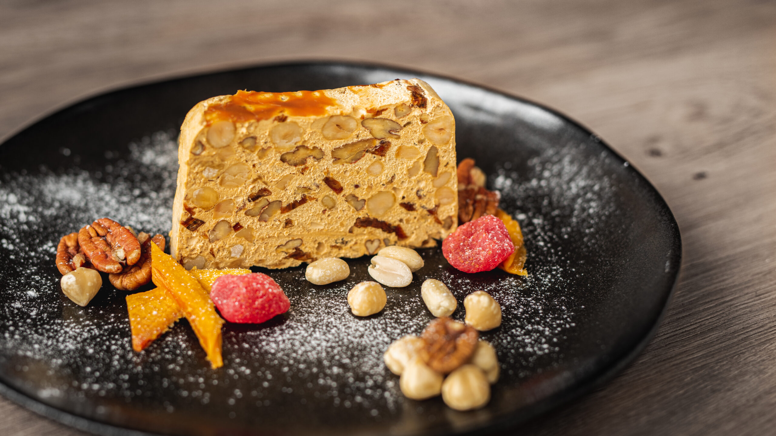 Ambachtelijke Banoffee nougat van ZinZetion met banaan en karamel, vers gesneden op een zwart stenen bord.